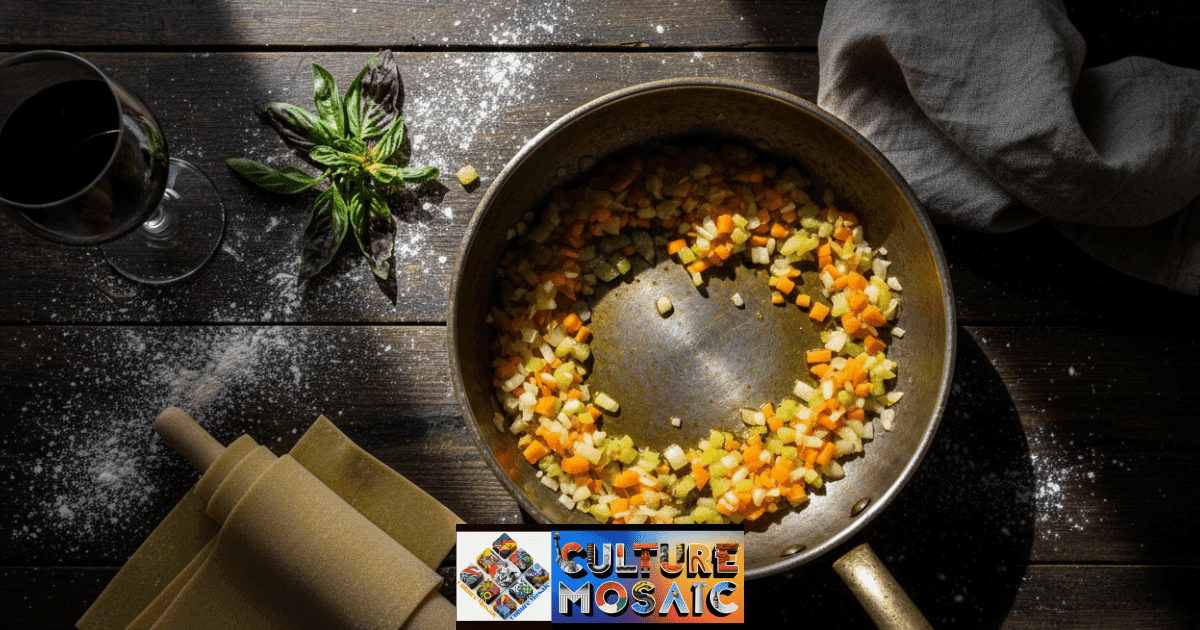 A rustic kitchen scene featuring traditional cooking methods in Italy, including a simmering soffritto in a copper pot and handmade pasta dough on a wooden table
