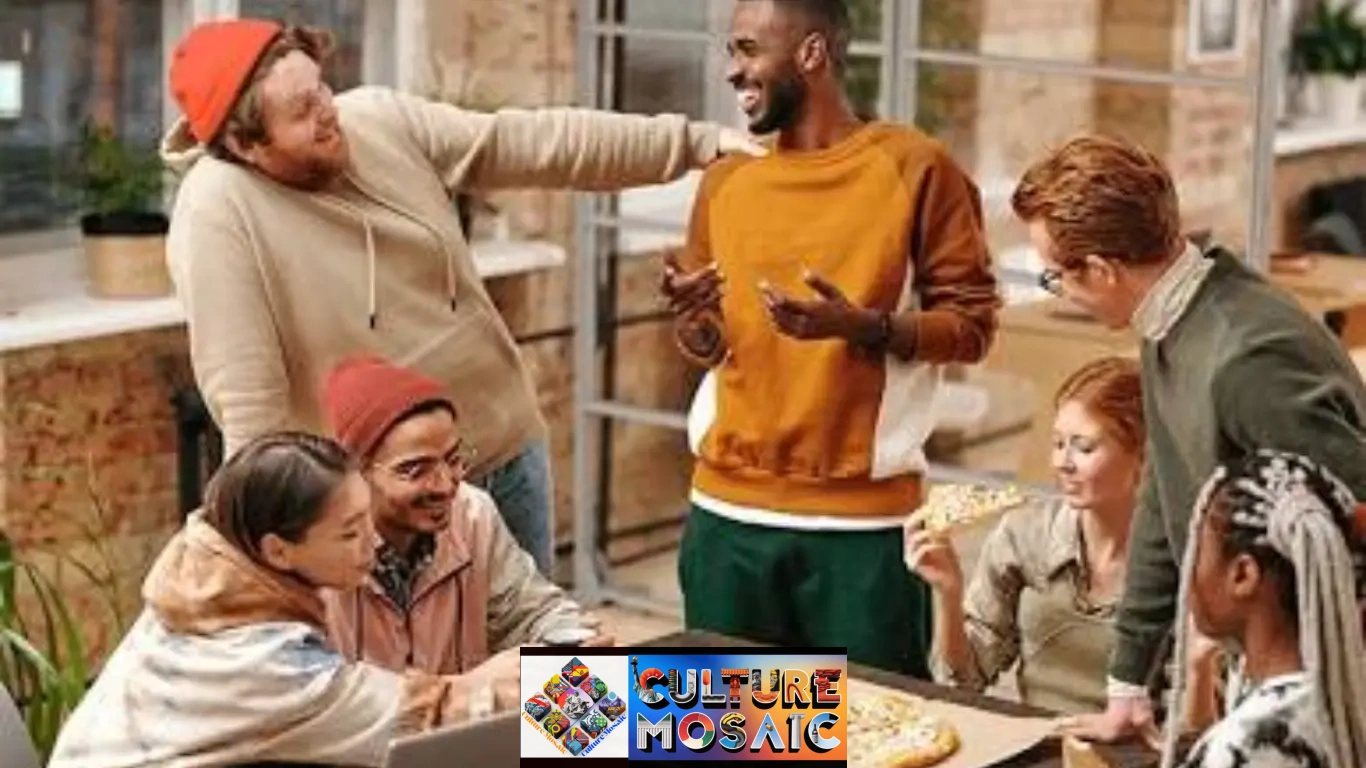 A diverse group of young adults and colleagues gathering around a wooden table in a modern office sharing pizza, laughing, and working together on a laptop, illustrating social change in modern society.