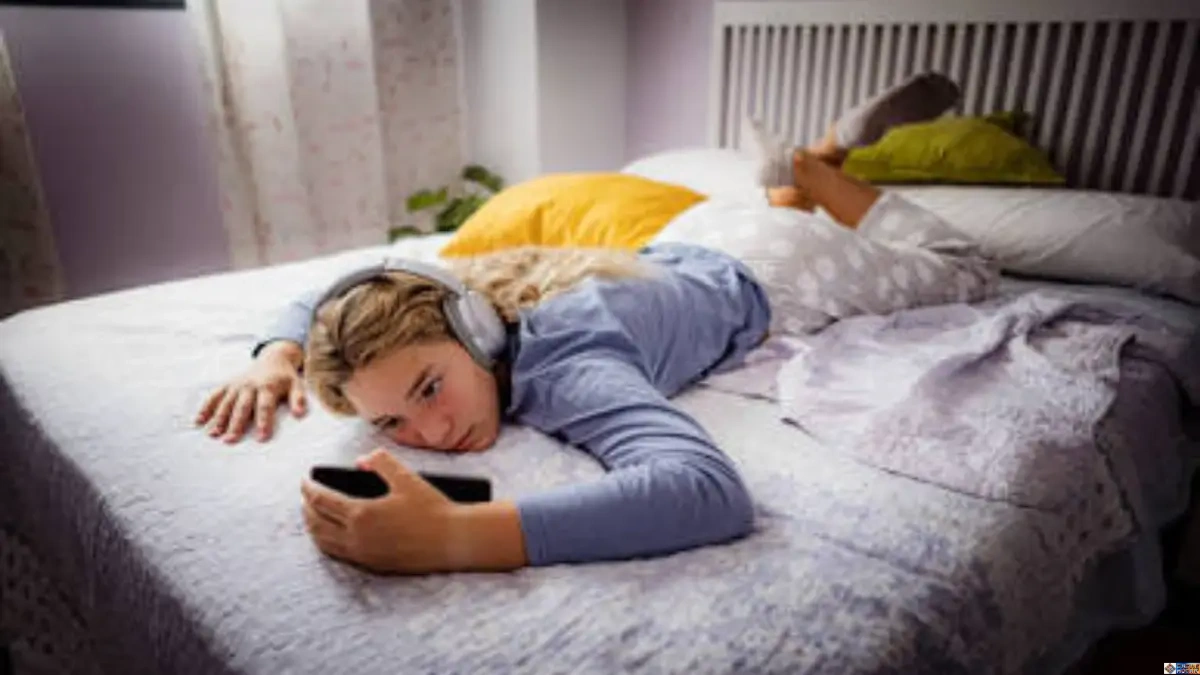 Exhausted music fan lying on a bed wearing headphones reflecting on the post concert hangover experience