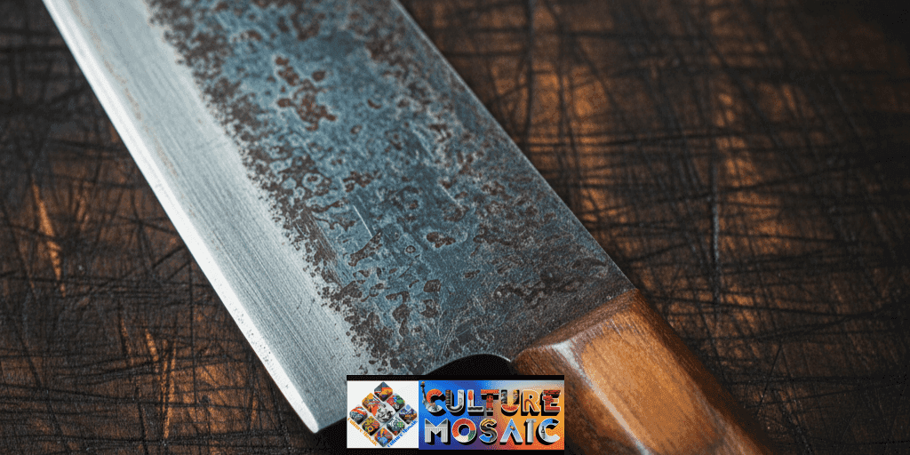 A macro photograph of a vintage Japanese kitchen knife showing a specific worn-down polish on the handle where the thumb and forefinger naturally grip the tool, illustrating procedural memory.